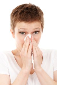 image of woman covering her nose with a tissue
