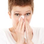 image of woman covering her nose with a tissue